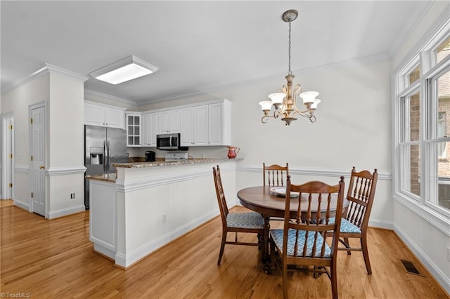 2014 Muirfield Ct, Elon, NC 27244 - dining space with light wood finished floors, a chandelier, crown molding, and baseboards
