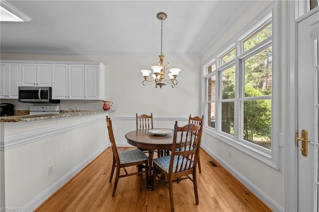 2014 Muirfield Ct, Elon, NC 27244 - dining space with light wood-type flooring, a chandelier, plenty of natural light, crown molding, and baseboards