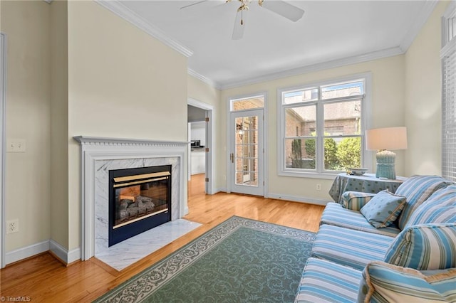 2014 Muirfield Ct, Elon, NC 27244 - living room featuring wood finished floors, ceiling fan, ornamental molding, a high end fireplace, and baseboards
