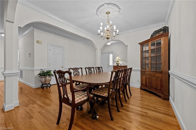 2014 Muirfield Ct, Elon, NC 27244 - dining space featuring arched walkways, light wood-type flooring, crown molding, and wainscoting