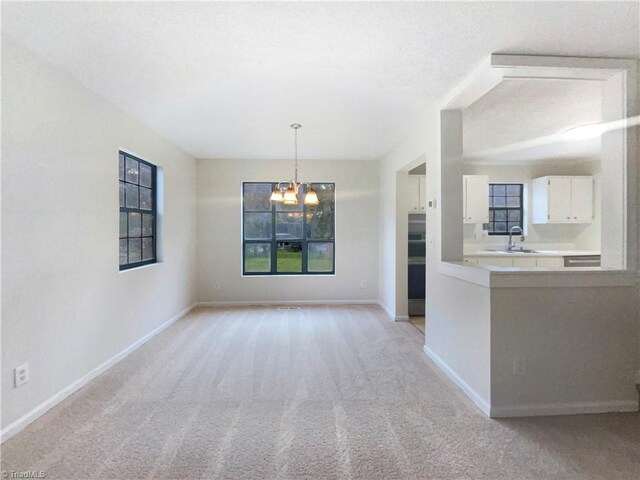 3877 Welcome Arcadia Rd, Lexington, NC 27295 - unfurnished dining area with light carpet, baseboards, an inviting chandelier, and a healthy amount of sunlight