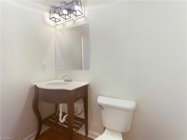 3877 Welcome Arcadia Rd, Lexington, NC 27295 - bathroom featuring toilet, baseboards, and a sink