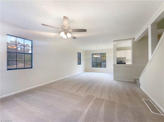 3877 Welcome Arcadia Rd, Lexington, NC 27295 - unfurnished room with ceiling fan with notable chandelier, baseboards, visible vents, and light colored carpet
