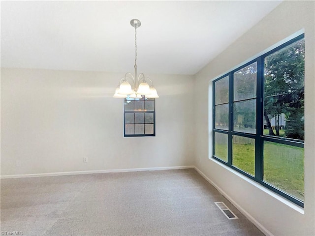 spare room featuring carpet and a notable chandelier