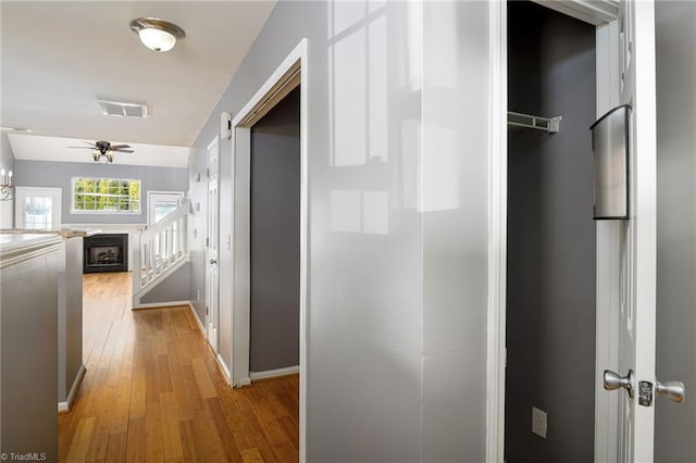 hall featuring a barn door and light hardwood / wood-style flooring