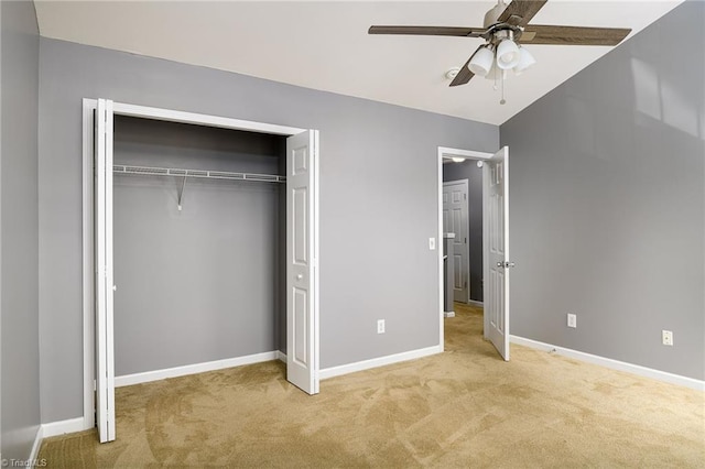 unfurnished bedroom featuring lofted ceiling, light carpet, ceiling fan, and a closet