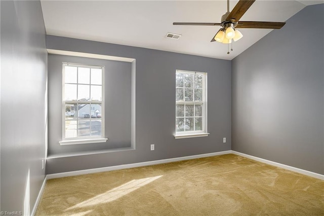 spare room featuring carpet floors, ceiling fan, and vaulted ceiling