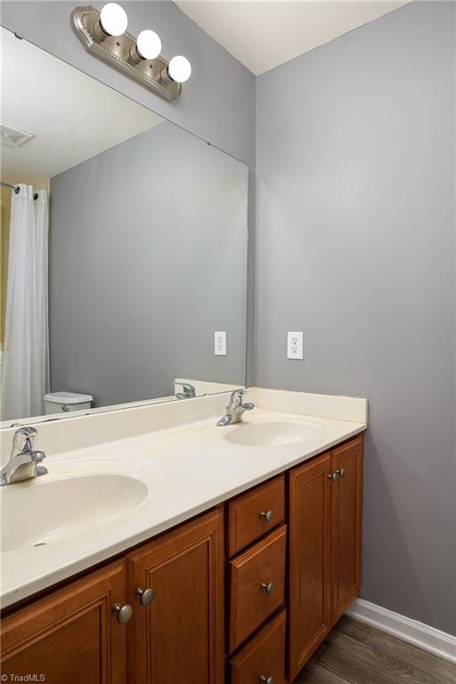 bathroom with vanity, hardwood / wood-style flooring, and toilet