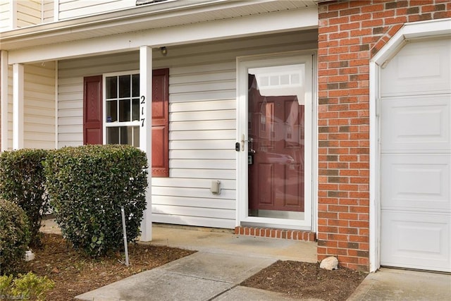 property entrance with a porch and a garage