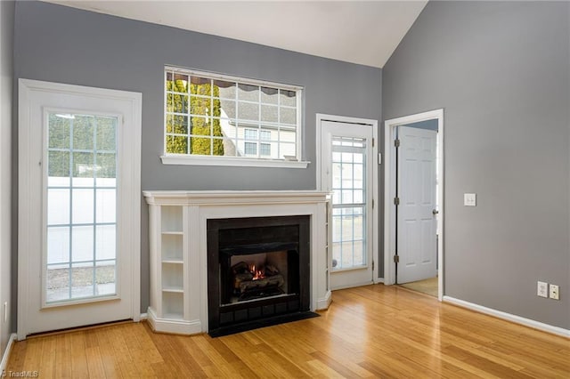 unfurnished living room featuring hardwood / wood-style flooring and vaulted ceiling