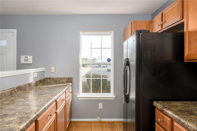 kitchen featuring black refrigerator and light hardwood / wood-style flooring