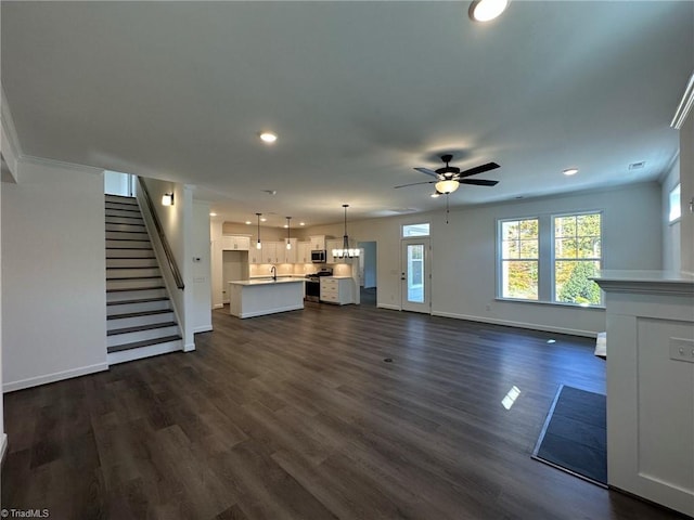 unfurnished living room featuring ceiling fan, dark hardwood / wood-style flooring, and crown molding