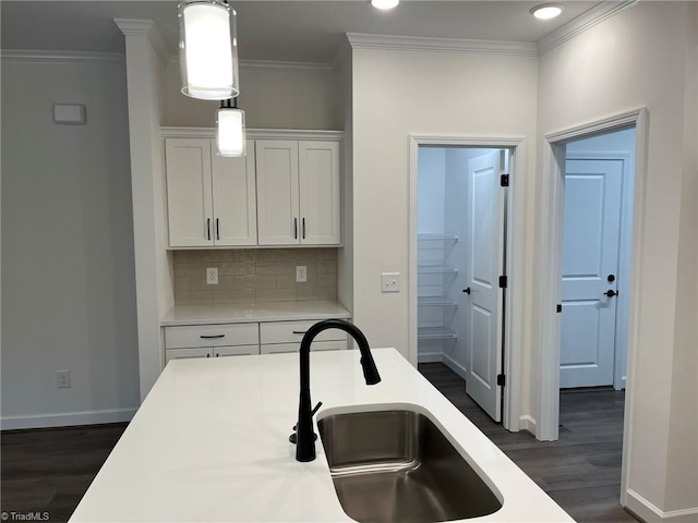 kitchen with white cabinetry, sink, dark hardwood / wood-style floors, backsplash, and decorative light fixtures