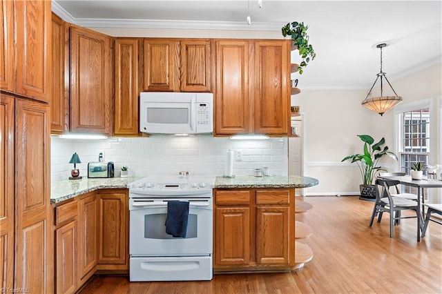 kitchen featuring white appliances, pendant lighting, brown cabinets, and ornamental molding