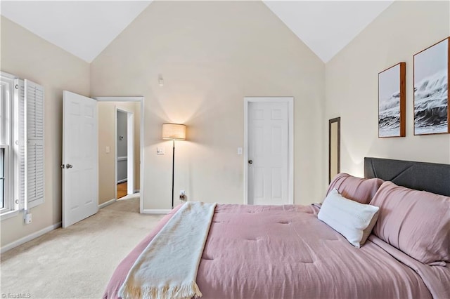 bedroom with high vaulted ceiling, light carpet, and baseboards