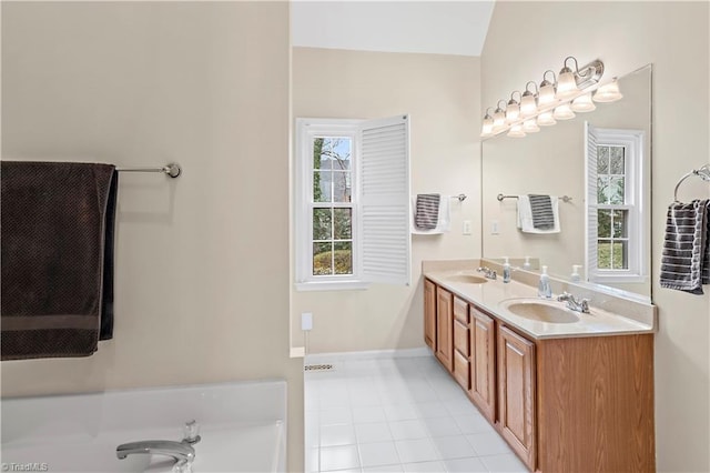 bathroom with a garden tub, double vanity, a sink, and tile patterned floors