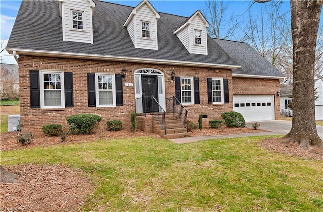 new england style home with an attached garage, concrete driveway, brick siding, and a shingled roof