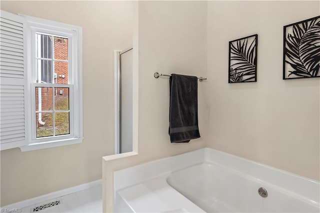 full bath with a garden tub and visible vents