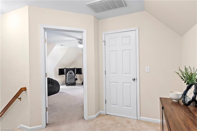 hallway featuring visible vents, vaulted ceiling, light carpet, and an upstairs landing