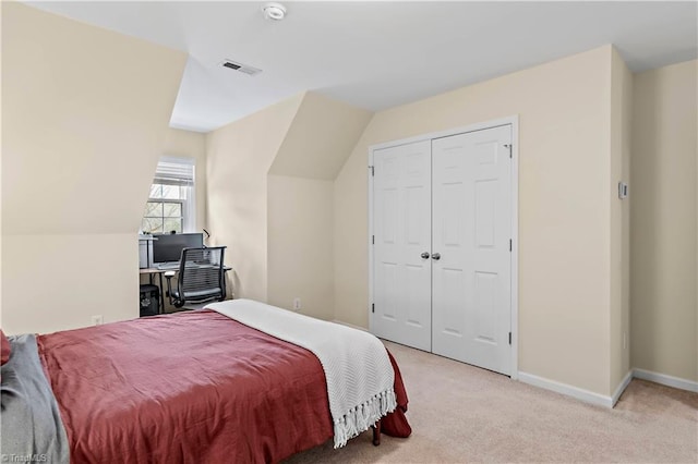 bedroom with light carpet, baseboards, visible vents, vaulted ceiling, and a closet