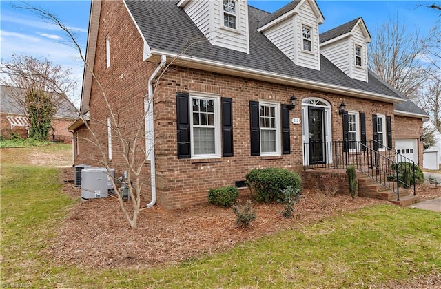 cape cod home with crawl space, brick siding, a front lawn, and roof with shingles