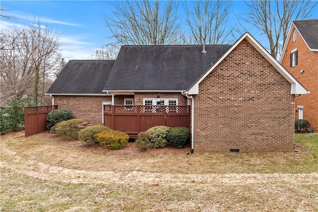 view of side of home featuring a shingled roof, brick siding, and fence