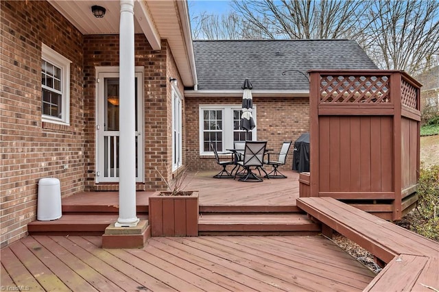 wooden terrace featuring a grill and outdoor dining area