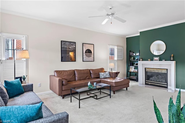 living room featuring light carpet, a ceiling fan, a high end fireplace, baseboards, and ornamental molding