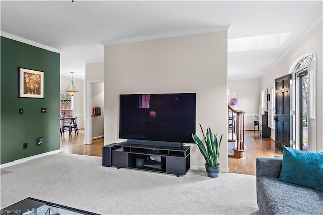 living area featuring stairs, carpet floors, ornamental molding, and baseboards