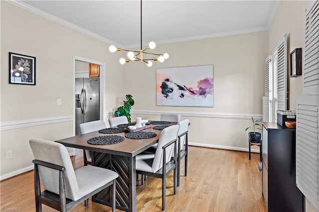 dining area featuring light wood-type flooring, a notable chandelier, crown molding, and baseboards