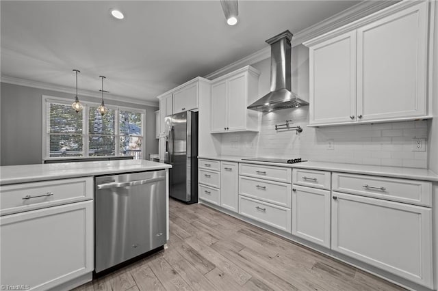 kitchen with appliances with stainless steel finishes, wall chimney range hood, light hardwood / wood-style flooring, and white cabinets