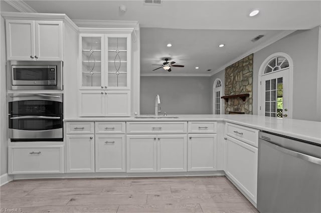 kitchen featuring appliances with stainless steel finishes, white cabinetry, sink, and light hardwood / wood-style flooring