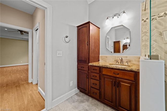 bathroom with hardwood / wood-style floors, ceiling fan, decorative backsplash, and vanity