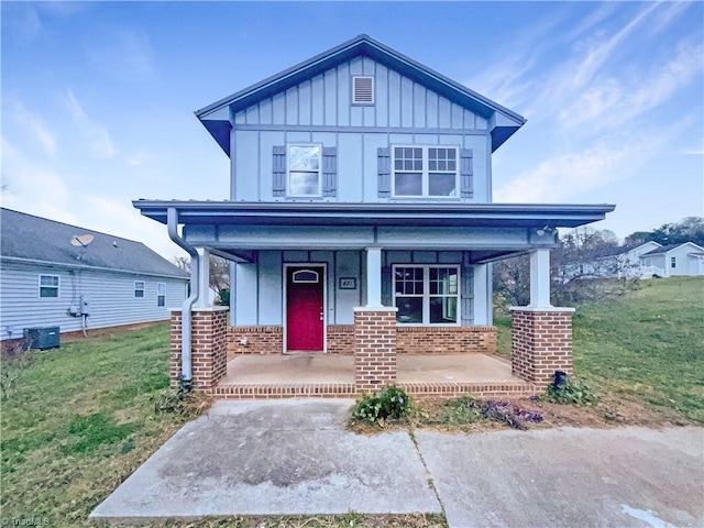 view of front of house with covered porch and a front lawn