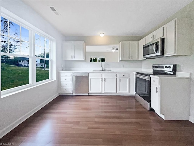 kitchen with white cabinetry, sink, stainless steel appliances, and dark hardwood / wood-style floors