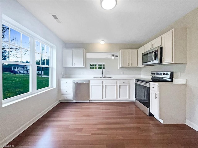 kitchen with sink, dark hardwood / wood-style floors, ceiling fan, appliances with stainless steel finishes, and white cabinetry