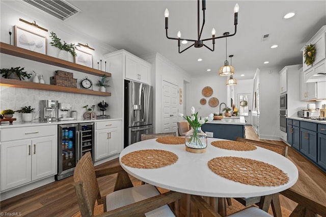 5120 Whaitley Ln, Greensboro, NC 27407 - dining room with beverage cooler, recessed lighting, wet bar, dark wood finished floors, and a chandelier
