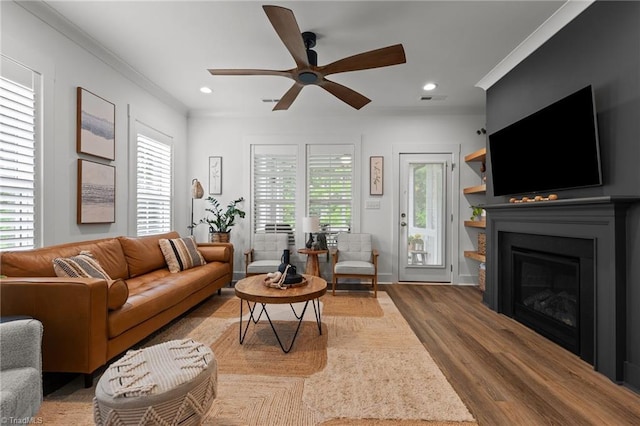 5120 Whaitley Ln, Greensboro, NC 27407 - living area featuring wood finished floors, ceiling fan, ornamental molding, a glass covered fireplace, and recessed lighting
