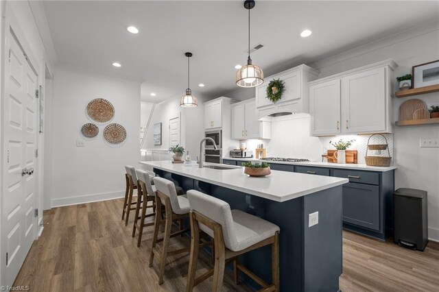 5120 Whaitley Ln, Greensboro, NC 27407 - kitchen with open shelves, stainless steel gas stovetop, a sink, light countertops, and a kitchen island with sink