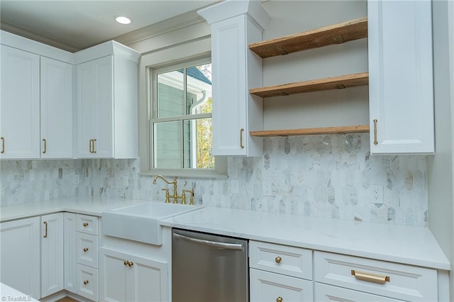 kitchen with sink, decorative columns, stainless steel dishwasher, white cabinetry, and tasteful backsplash