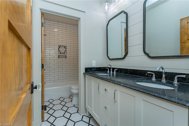 full bathroom featuring vanity, toilet, tiled shower / bath combo, and tile patterned flooring