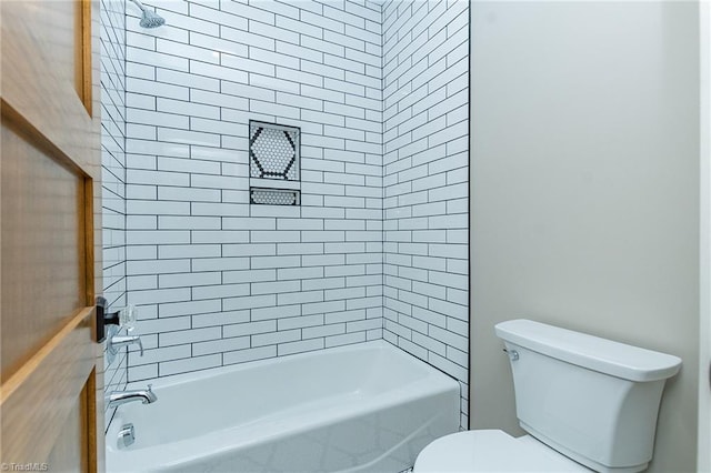 bathroom with toilet and tiled shower / bath