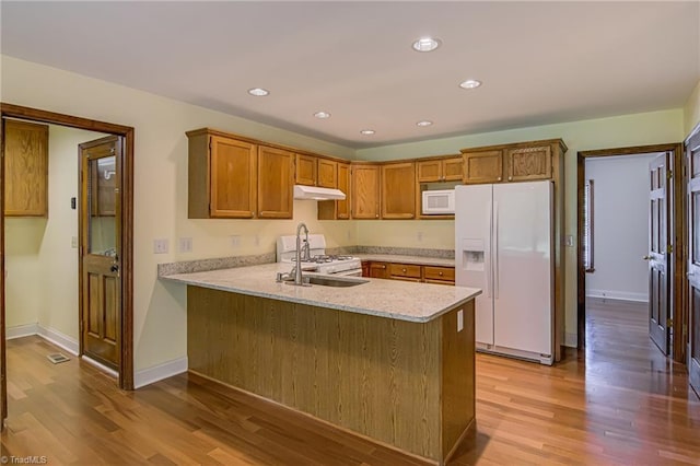 417 Avery Ave, High Point, NC 27265 - kitchen with white appliances, under cabinet range hood, light wood-style floors, a peninsula, and recessed lighting