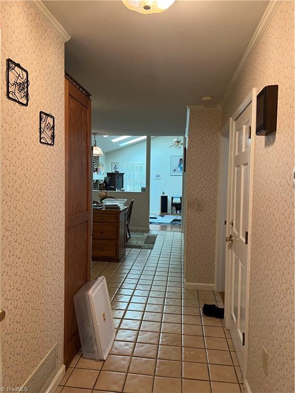 209 Cedar Ln, North Wilkesboro, NC 28659 - corridor with ornamental molding, wallpapered walls, light tile patterned floors, and a desk