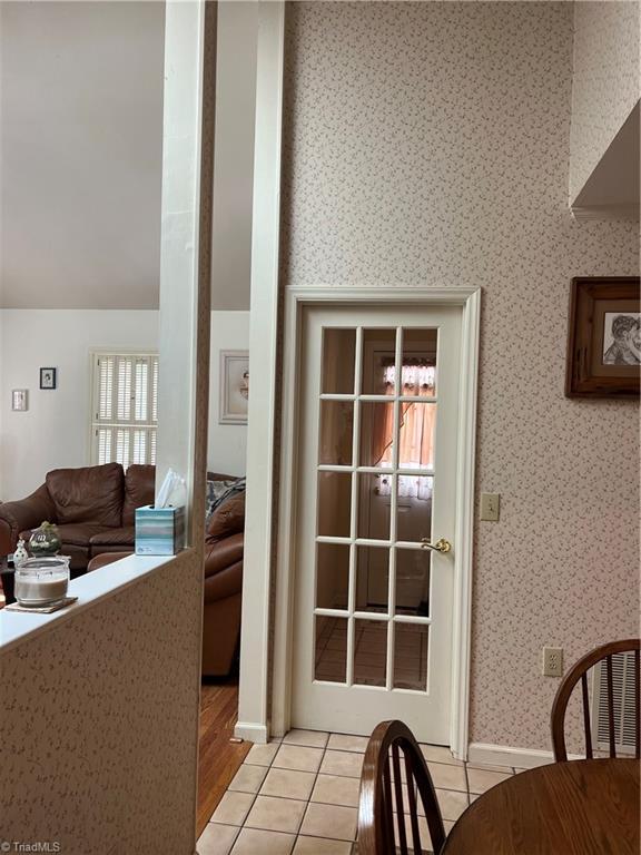 209 Cedar Ln, North Wilkesboro, NC 28659 - doorway to outside featuring wallpapered walls, light tile patterned flooring, and baseboards