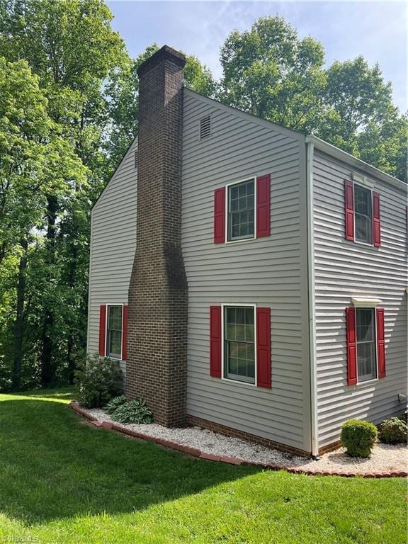 209 Cedar Ln, North Wilkesboro, NC 28659 - view of home's exterior with a chimney and a lawn