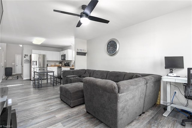 living room with ceiling fan and light wood-type flooring