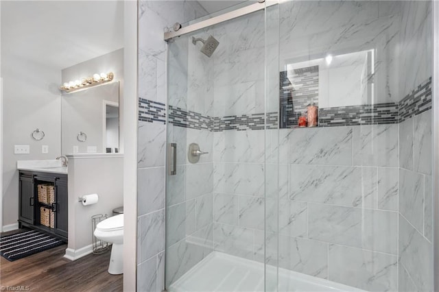 bathroom featuring wood-type flooring, vanity, toilet, and walk in shower