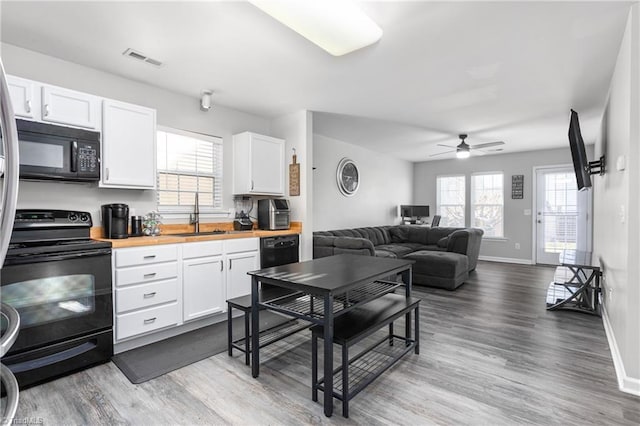 kitchen with black appliances, white cabinets, sink, ceiling fan, and butcher block countertops