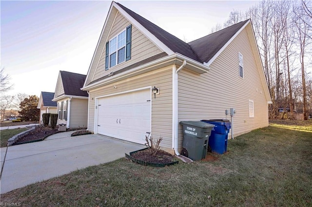 property exterior at dusk with a garage and a lawn